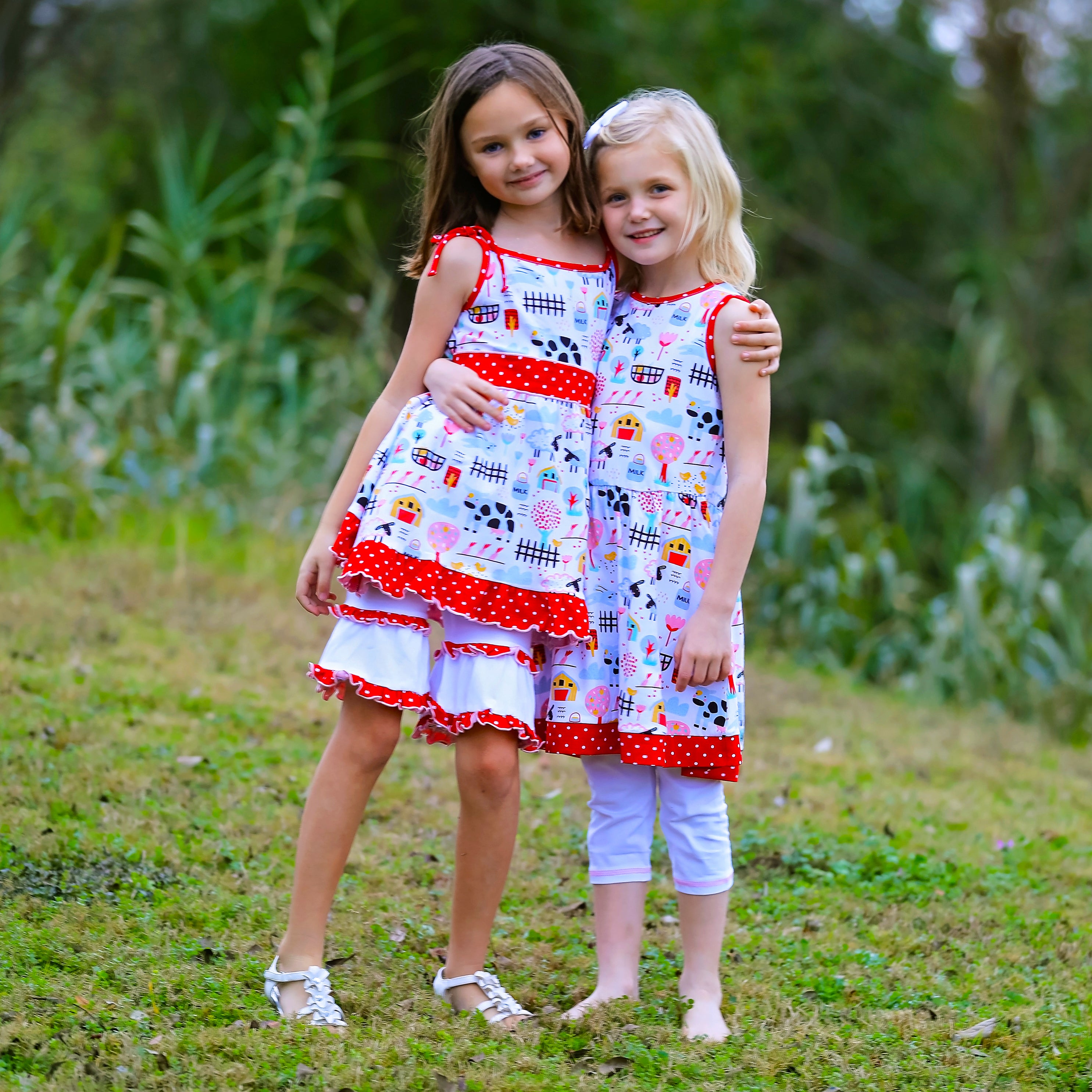 AnnLoren Little & Big Girls Farm Animals Dress with Capri Ruffle featuring farm animal print and pink-red polka dot sash.